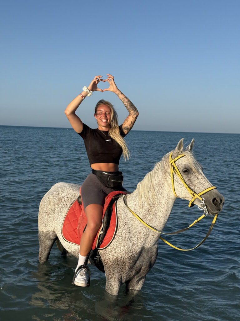 Woman enjoying a horse swimming experience in Hurghada, Egypt.